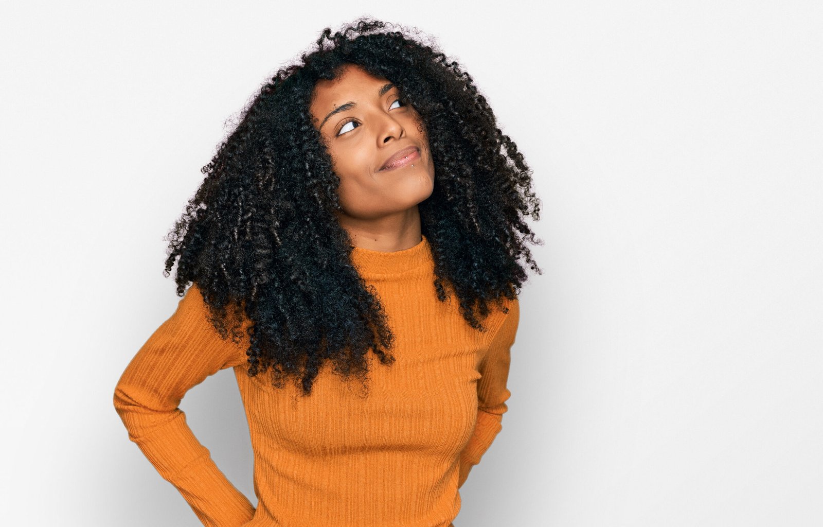 Young african american girl wearing casual clothes smiling looking to the side and staring away thinking.