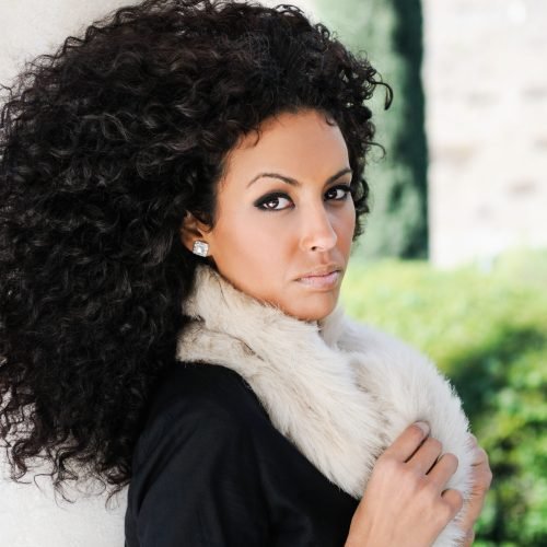 Portrait of a young black woman, afro hairstyle, in urban background